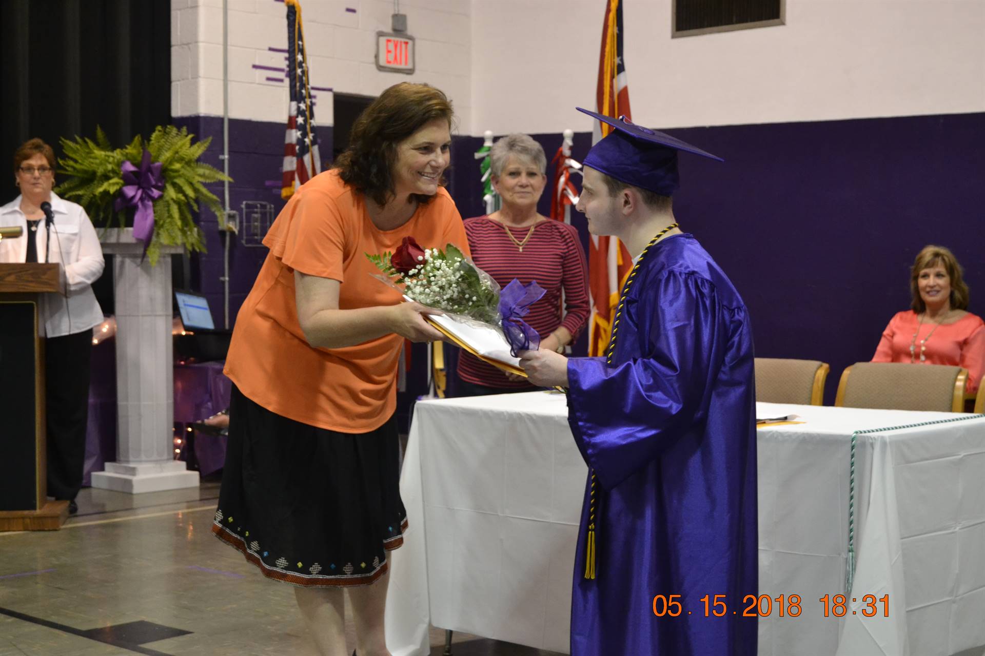 Superintendent handing diploma to student